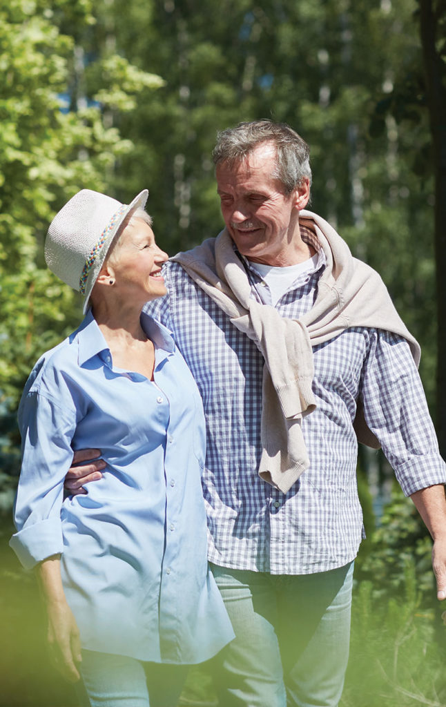 portrait of senior couple taking a walk and smiling up at each other successful retirement