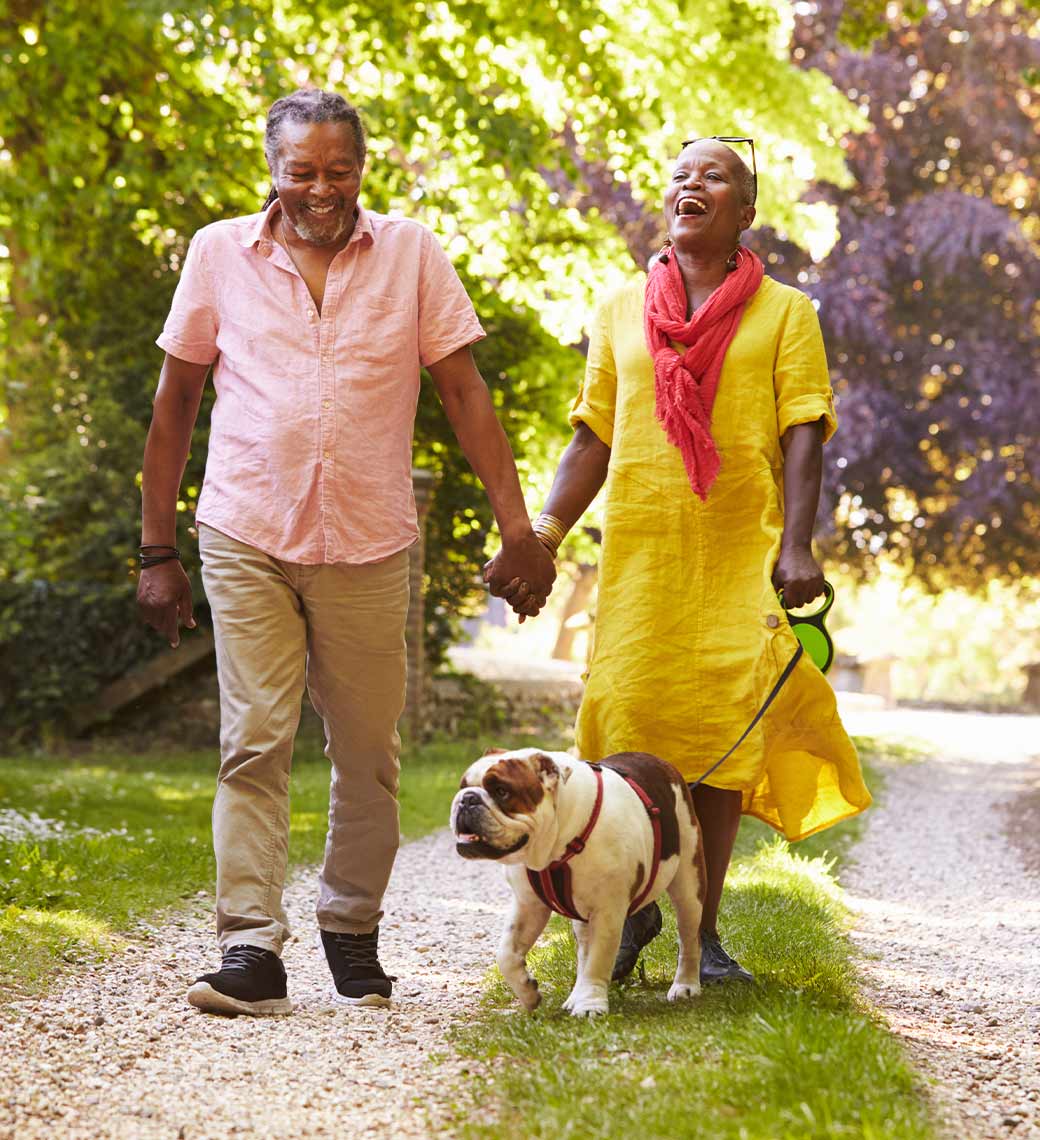 happy retired couple walking hand in hand with their dog annuities for retirement